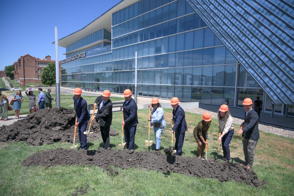 people tossing dirt at the groundbreaking event