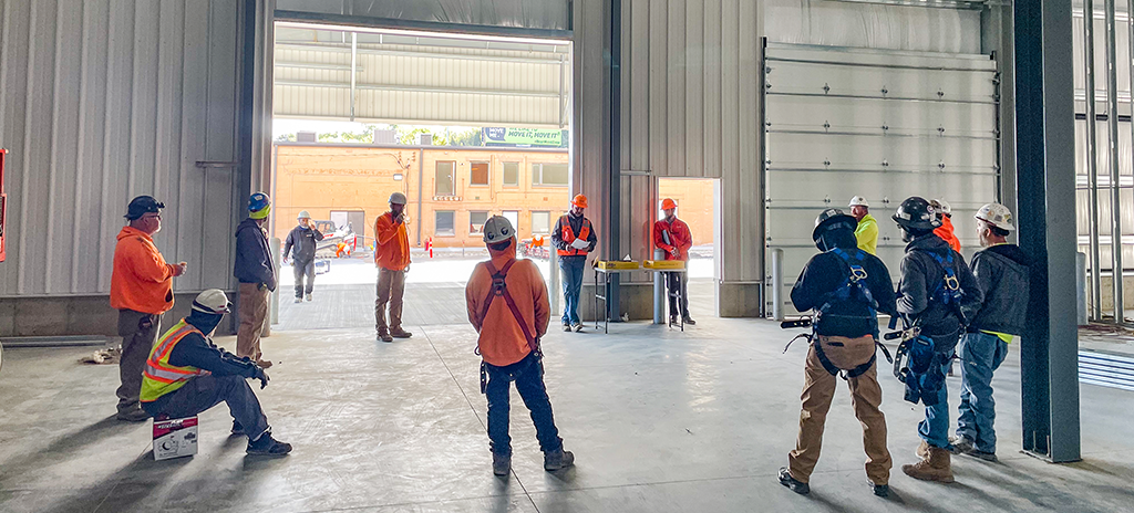 subcontractors standing around a superintendent at a jobsite